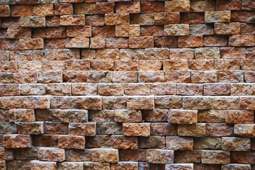Rough brick wall with uneven offset bricks