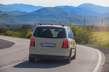 Obraz na płótnie Canvas Minivan is moving along a winding road in a mountainous area