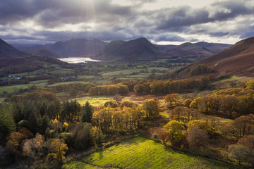 Beautiful aerial drone Autumn Fall landscape image of view from Low Fell in Lake District looking towards Crummock Water and Mellbreak and Grasmoor peaks