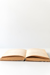 Close up shot of an open old science book containing equations and graphs from different fields: math, physics, chemistry. The pages have the marks of the past as they got orange.