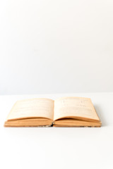 Close up shot of an open old science book containing equations and graphs from different fields: math, physics, chemistry. The pages have the marks of the past as they got orange.