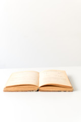 Close up shot of an open old science book containing equations and graphs from different fields: math, physics, chemistry. The pages have the marks of the past as they got orange.