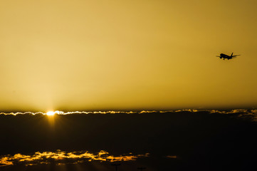 Jet plane landing in sunrise time in front of dramatic sky.