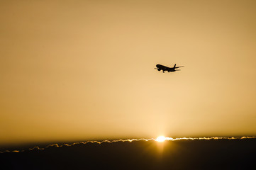 Jet plane landing in sunrise time in front of dramatic sky.