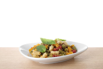 Delicious vegetable spiraline pasta with basil on wooden table