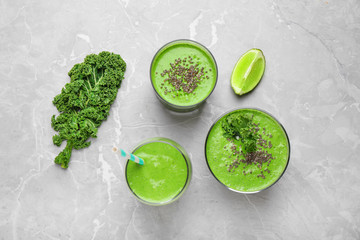 Tasty kale smoothie on light grey marble table, flat lay