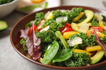 Tasty fresh kale salad on light grey table, closeup