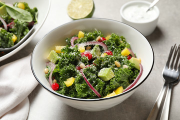 Tasty fresh kale salad on grey table, closeup