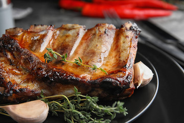 Tasty grilled ribs with thyme on plate, closeup