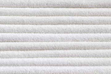 Stack of white plush hotel towels isolated on white background