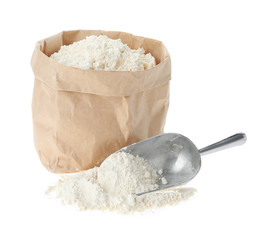 Paper bag and scoop with flour isolated on white