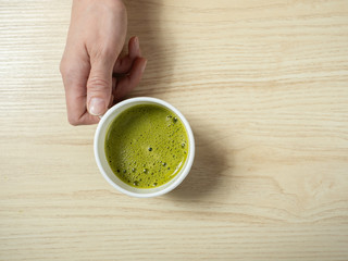 Woman drinking matcha tea, on the kitchen