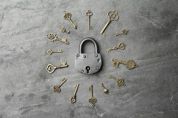 Steel padlock and keys on grey background, top view. Safety concept