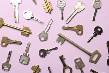 Steel keys on pink background, flat lay. Safety concept