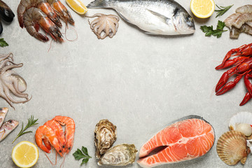 Fresh fish and seafood on light grey table, flat lay. Space for text