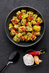 Aloo Methi in copper kadai, bowl at dark slate background. Aloo Methi is indian cuisine dish with Potato, Fenugreek and Spices. Indian Food. Top view