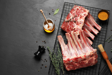 Raw ribs with thyme and pepper on black table, flat lay