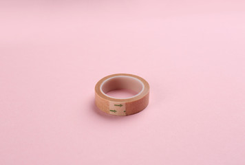 Medical sticking plaster roll on pink background