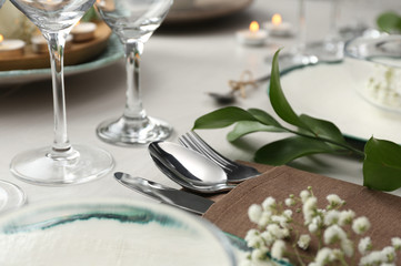 Obraz na płótnie Canvas Elegant cutlery with green plants on table, closeup. Festive setting