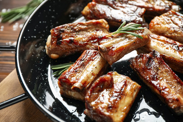 Delicious grilled ribs with rosemary on table, closeup