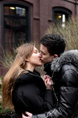 Happy young couple in love kiss on the street. Valentine's Day.