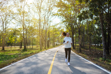 A young asian woman jogging in city park in the morning