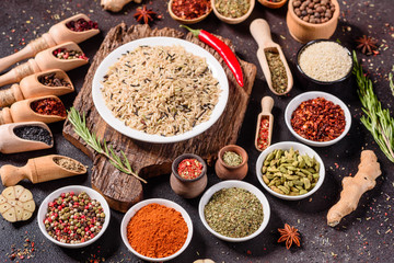 Spices and herbs over black stone background. Top view with free space for menu or recipes