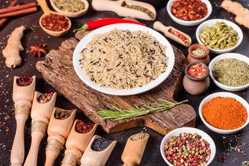 Spices and herbs over black stone background. Top view with free space for menu or recipes