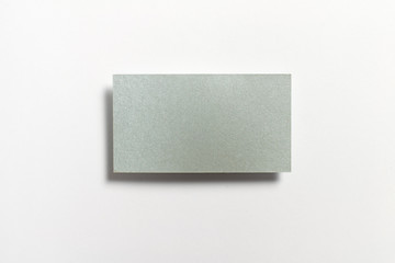 Silver blank matt textured business card flying and isolated on white paper background, us standard size 3.5 x 2 inches, real non professional studio photo.