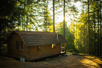 Beautiful cabin in the woods during sunrise in the middle of nowhere on private island in Canada Vancouver Island sunset 