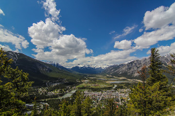 Lookout view of Banff town in Canada Alberta Rocky Mountains overlooking mountains with blue sky and clouds 