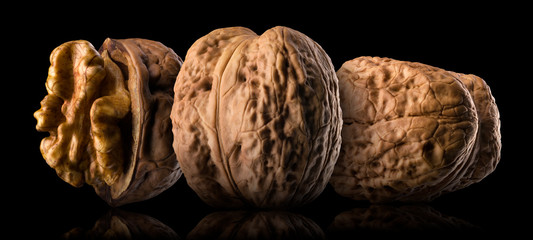 Fototapeta na wymiar Set of whole walnuts isolated on a black background