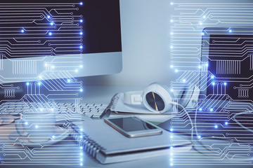 Computer on desktop in office with technology theme hologram. Multi exposure. Tech concept.