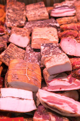 Smoked meat delicacies and sausages on the market balyk of various meats in a shop window. Deli display cold meat and salami. Balyks and various meat delicacies. vertical photo