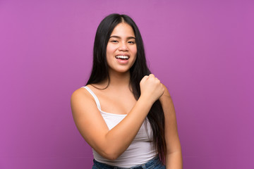 Obraz premium Young teenager Asian girl over isolated purple background celebrating a victory
