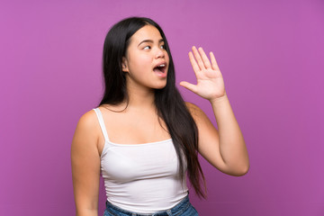 Young teenager Asian girl over isolated purple background shouting with mouth wide open