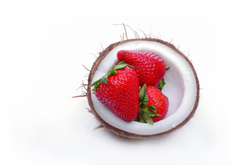 Half of fresh coconut with strawberry on a white background. Coconut bowl with red berries inside, healthy, vegan, food, fashion, tropical concept with a copy space.