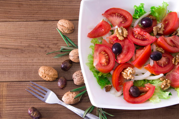 Fototapeta na wymiar Vegetable salad with nuts and olives, diet and health concept