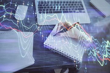Financial graph displayed on woman's hand taking notes background. Concept of research. Multi exposure