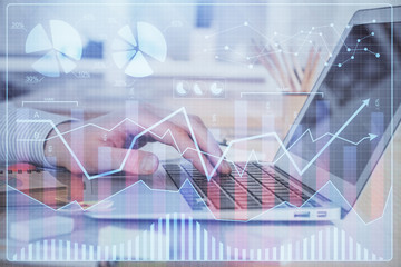 Double exposure of stock market graph with man working on laptop on background. Concept of...