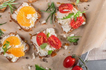 Mini canapes with cheese, tomatoes and tangerines