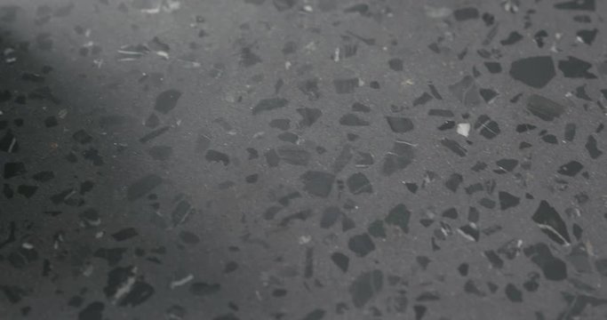 Handheld slow motion of frisee leaves in white bowl on terrazzo surface