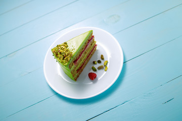 Cake with fruity cream and pistachio decorated with nuts, isolated.