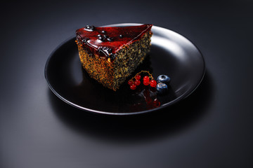 Cake with berry fruits, chia cereals and nuts isolated on black background