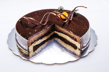 Chocolate cake with decoration and fruits on white background