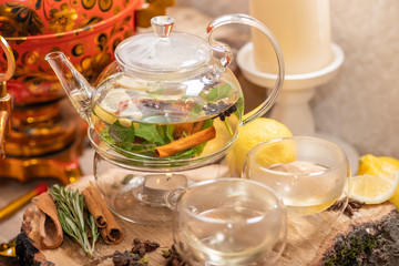 Hot green tea candle basking with lemon, mint, ginger, cinnamon and honey on wooden background. Food and drink, still life health care concept.