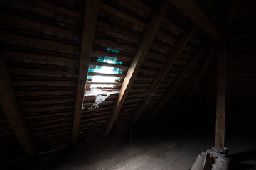 Inside the attic of an old house with cobwebs.