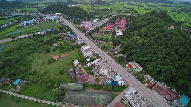 VDO. Aerial view evening above urban, road, building and buddhist temple, Wat Khao Chong Pran (Bat Temple), Photharam, Ratchaburi, west of Thailand.