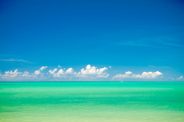 Obraz premium Tropical sea background in vibrant hues of turquoise blue with low clouds on the horizon 