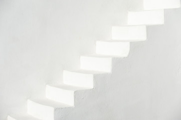 Traditional whitewashed Mediterranean staircase in Santorini, Greece with white stucco copy space